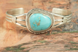 Genuine Castle Dome Turquoise set in Sterling Silver Bracelet. The Castle Dome Turquoise Mine is located about 30 miles from the Sleeping Beauty Mine, near Globe, Arizona. The Castle Dome Mine has not been in operation since the early 1970s. Created by Navajo Artist Arkie Nelson. Signed by the artist.